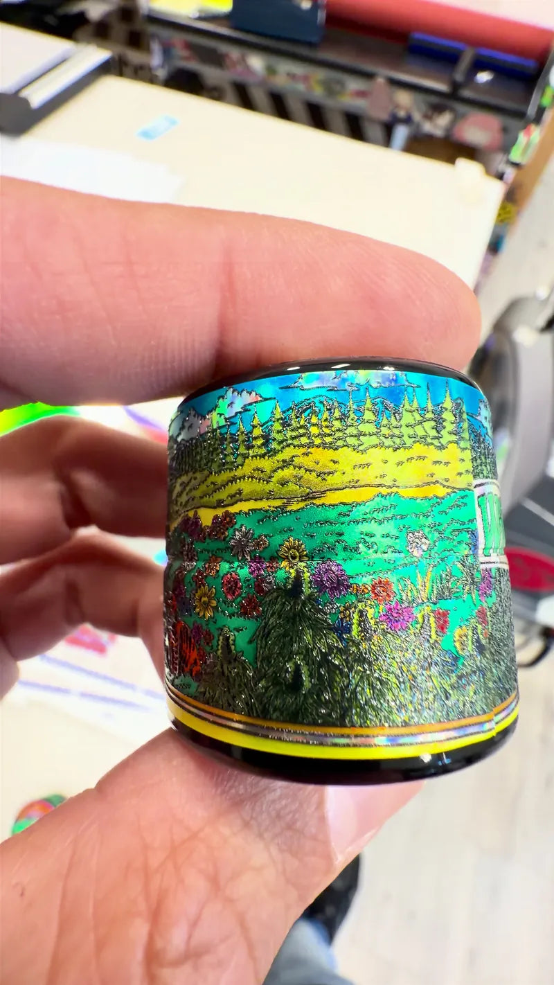 Holographic illustrated jar wrap held in a hand