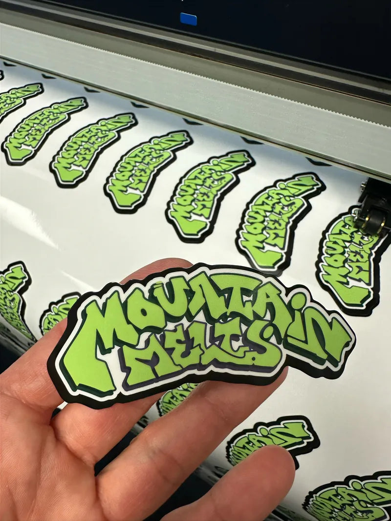 Mountain Melts sticker held over printed sheets